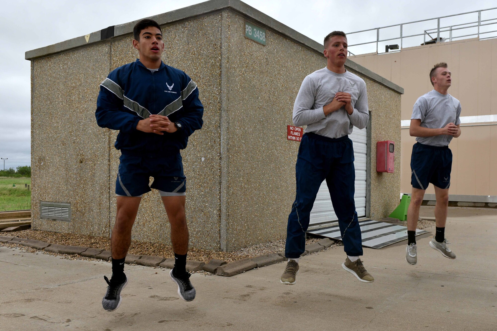 Airman Jake Peterson, Airman 1st Class Garrett Rivett and Airman Haden Stoner, 312th Training Squadron students, perform jump-squats during the Blood, Sweat and Stairs competition at the Louis F. Garland Department of Defense Fire Academy on Goodfellow Air Force Base, Texas, Sept. 22, 2018. Due to poor weather conditions, the coordinators removed the stair-climbing portion from the competition, and participants performed cardio-based exercises instead. (U.S. Air Force photo by Senior Airman Randall Moose/Released)
