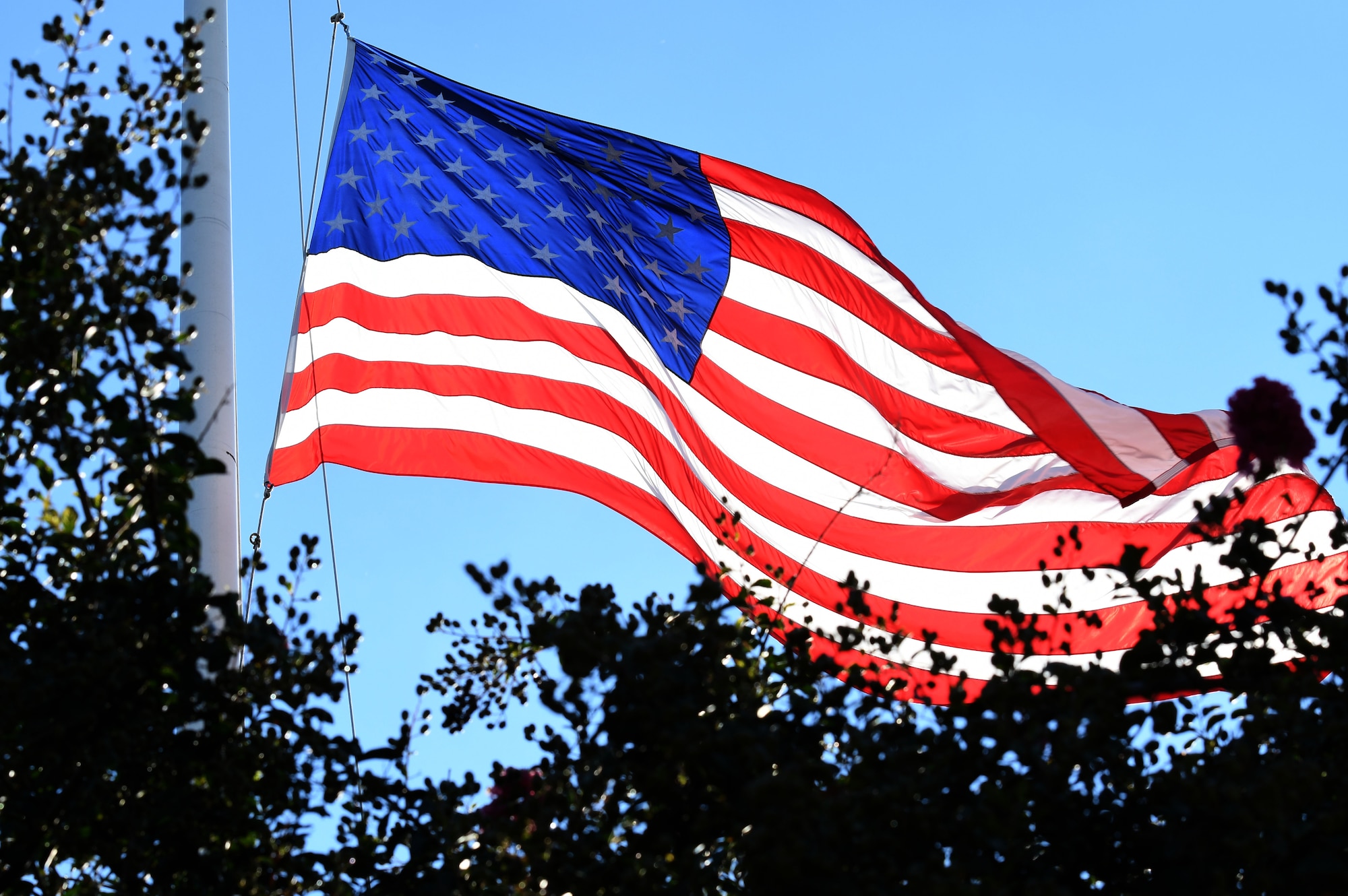 The U.S. Flag is lowered during the POW/MIA Retreat Ceremony at Keesler Air Force Base, Mississippi, Sept. 20, 2018. The event was held to raise awareness and to pay tribute to all prisoners of war and those military members still missing in action. (U.S. Air Force photo by Kemberly Groue)