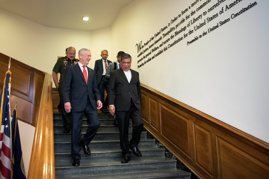 Defense Secretary James N. Mattis walks down steps with Malaysian Defense Minister Mohamad Sabu.