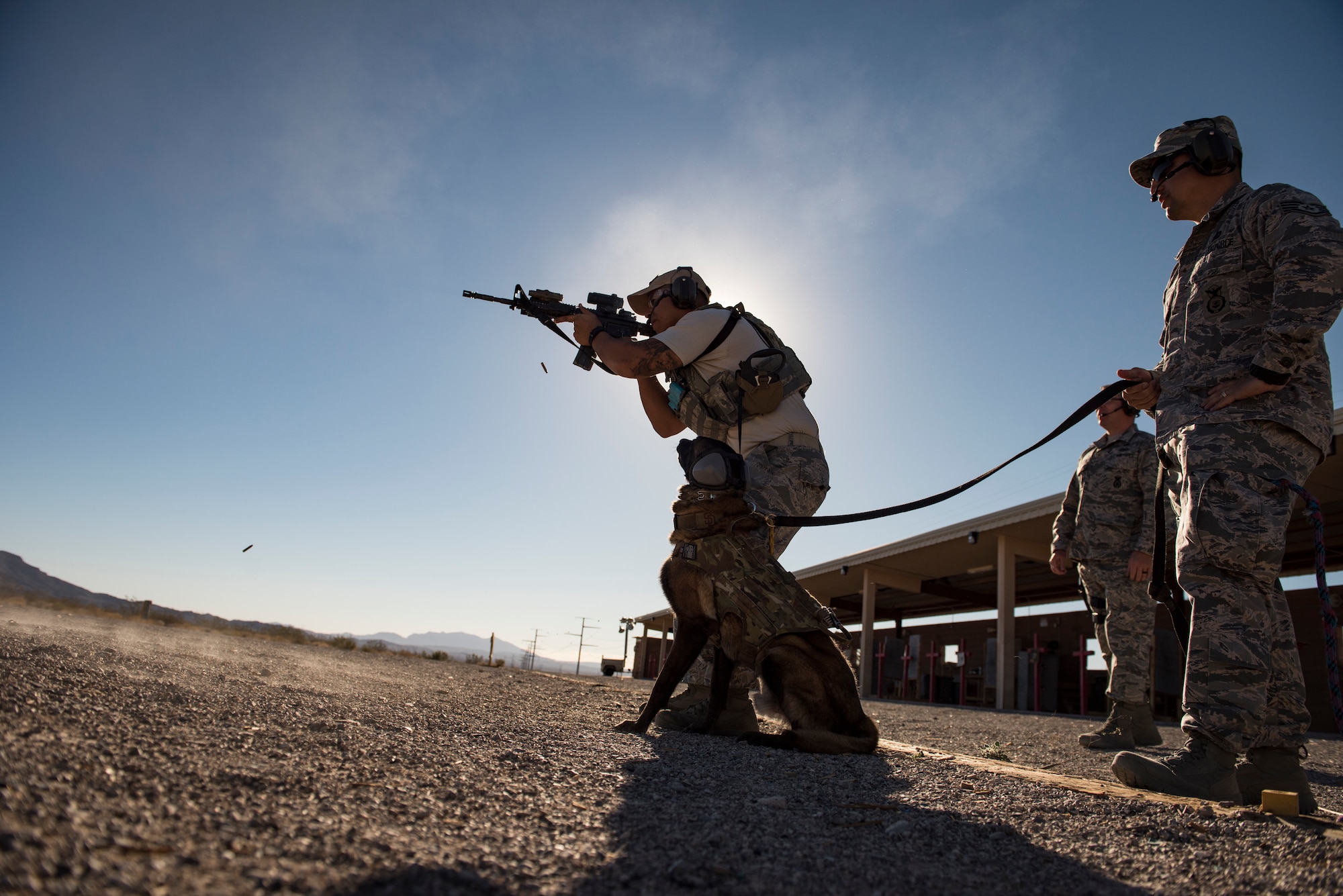 Staff. Sgt. Juan Hinojosa, 99th Security Forces Squadron military working dog handler, fires a rifle at Nellis Air Force Base, Nevada, Sept. 19, 2018. Each member maneuvered to different stations where they fired their rifle and pistol while maintaining control over their military working dogs. (U.S. Air Force photo by Airman 1st Class Andrew D. Sarver)
