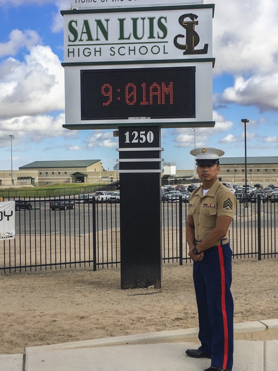 Sergeant Edwin Carranza, a canvassing recruiter with Recruiting Station Phoenix, poses in front of San Luis High School in San Luis, Ariz., Sept. 20 2018. Carranza attended this high school and has returned as a canvassing recruiter with Recruiting Station Phoenix. (U.S. Marine Corps photo by Sgt. Alvin Pujols)