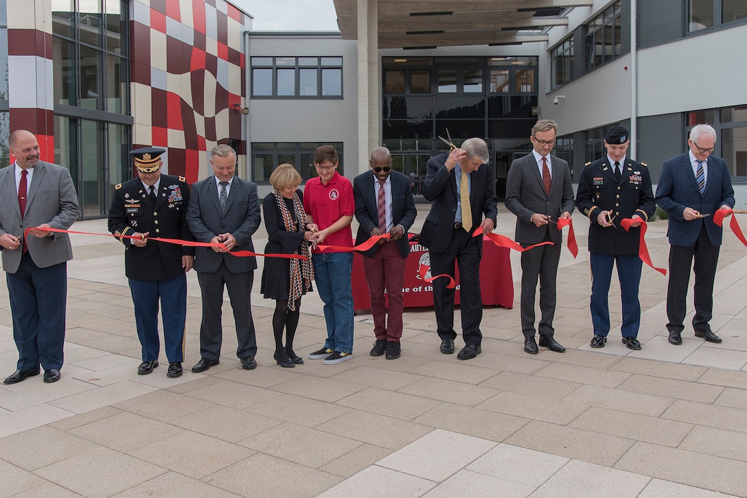 A group of people cut a red ribbon.