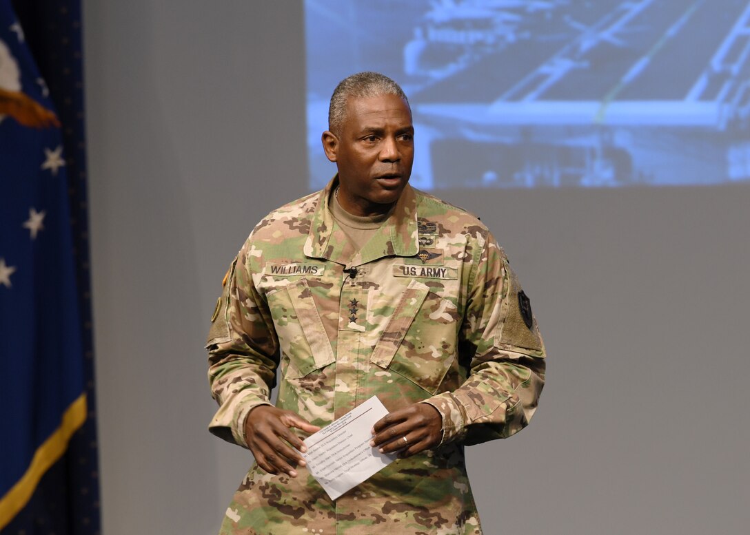 Army lieutenant general in fatigues, facing viewer on stage