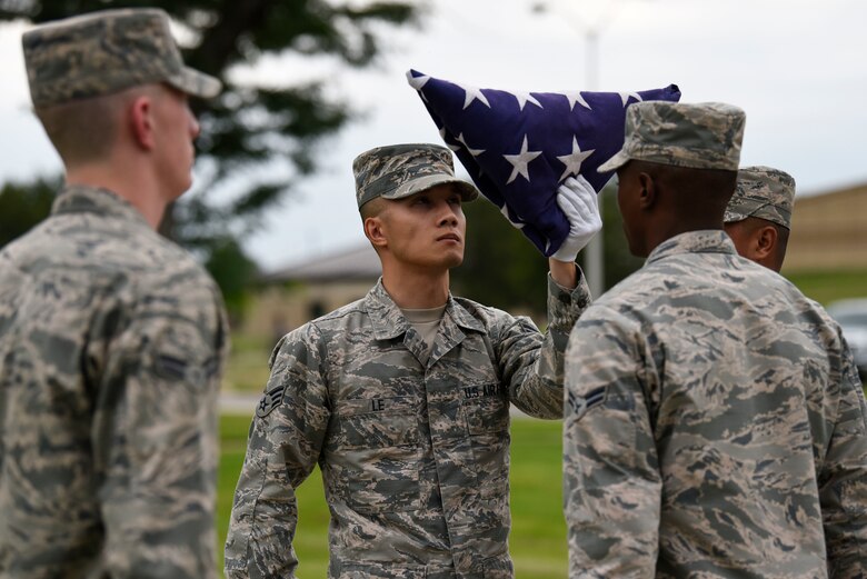 Members of the Dover Air Force Base Honor Guard inspect a folded American flag during a POW/MIA retreat ceremony Sept. 21, 2018, at Dover AFB, Del. The base honor guard also performed a rifle salute and played taps on the bugle. (U.S. Air Force photo by Airman 1st Class Zoe M. Wockenfuss)
