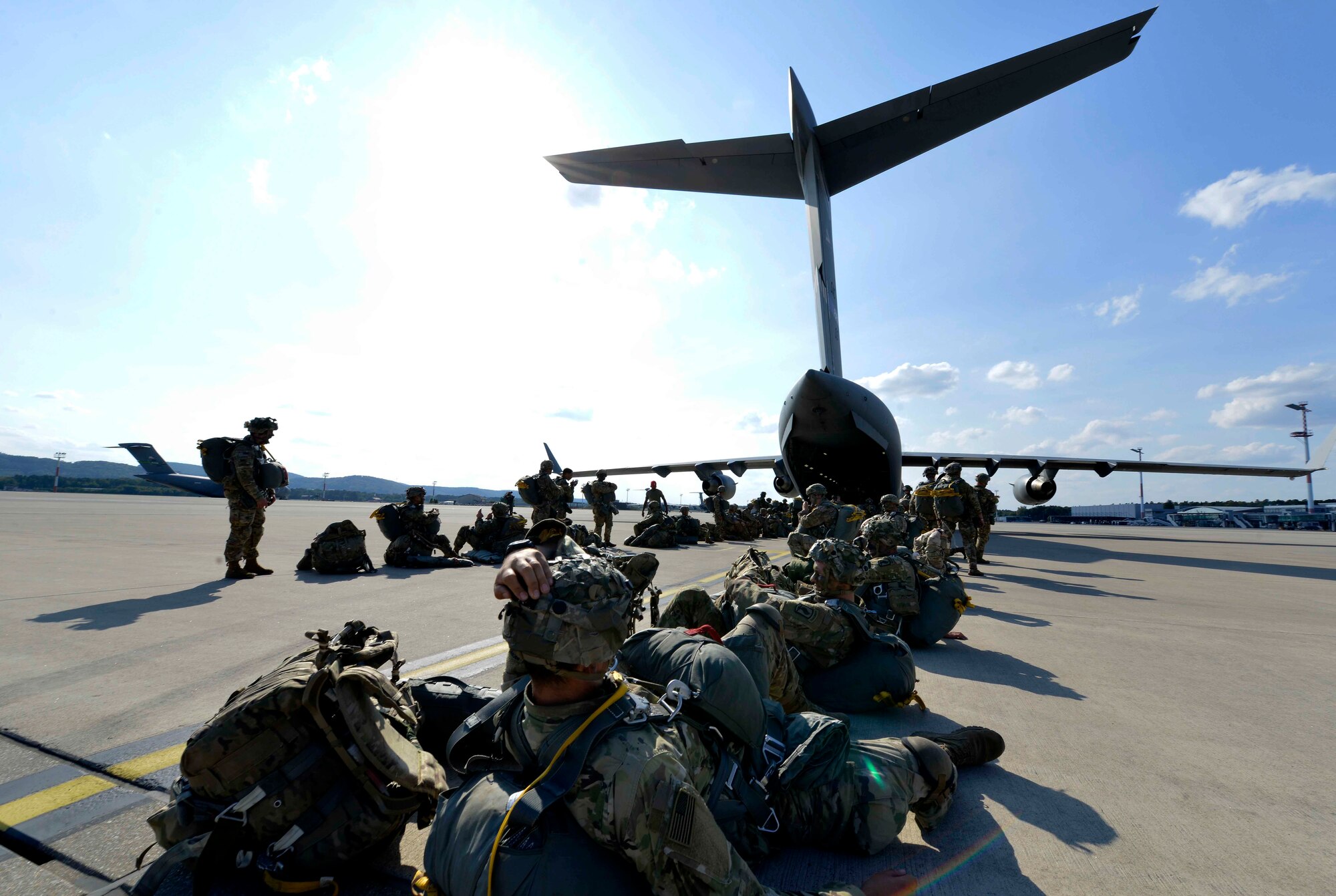 U.S. and Italian soldiers wait to load onto a C-17 Globemaster III as part of Saber Junction 18 on Ramstein Air Base, Germany, Sep. 19, 2018. Allies and partners use the opportunity provided by the exercises to work through their own training objectives while also working on interoperability solutions. (U.S. Air Force photo by Senior Airman Alexis Schultz)