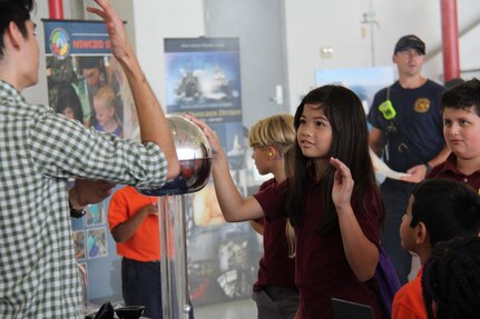 IMAGE: VIRGINIA BEACH, Va. (Sep. 21, 2018) - Virginia Beach elementary school students learn about static electricity from a Navy science, technology, engineering and mathematics (STEM) team at the annual NAS Oceana Air Show. The team of 30 STEM professionals from Naval Surface Warfare Center Dahlgren Division, NSWCDD Dam Neck Activity, and Dahlgren’s Sly Fox program led education efforts through hands-on displays to fifth grade students throughout the air show.