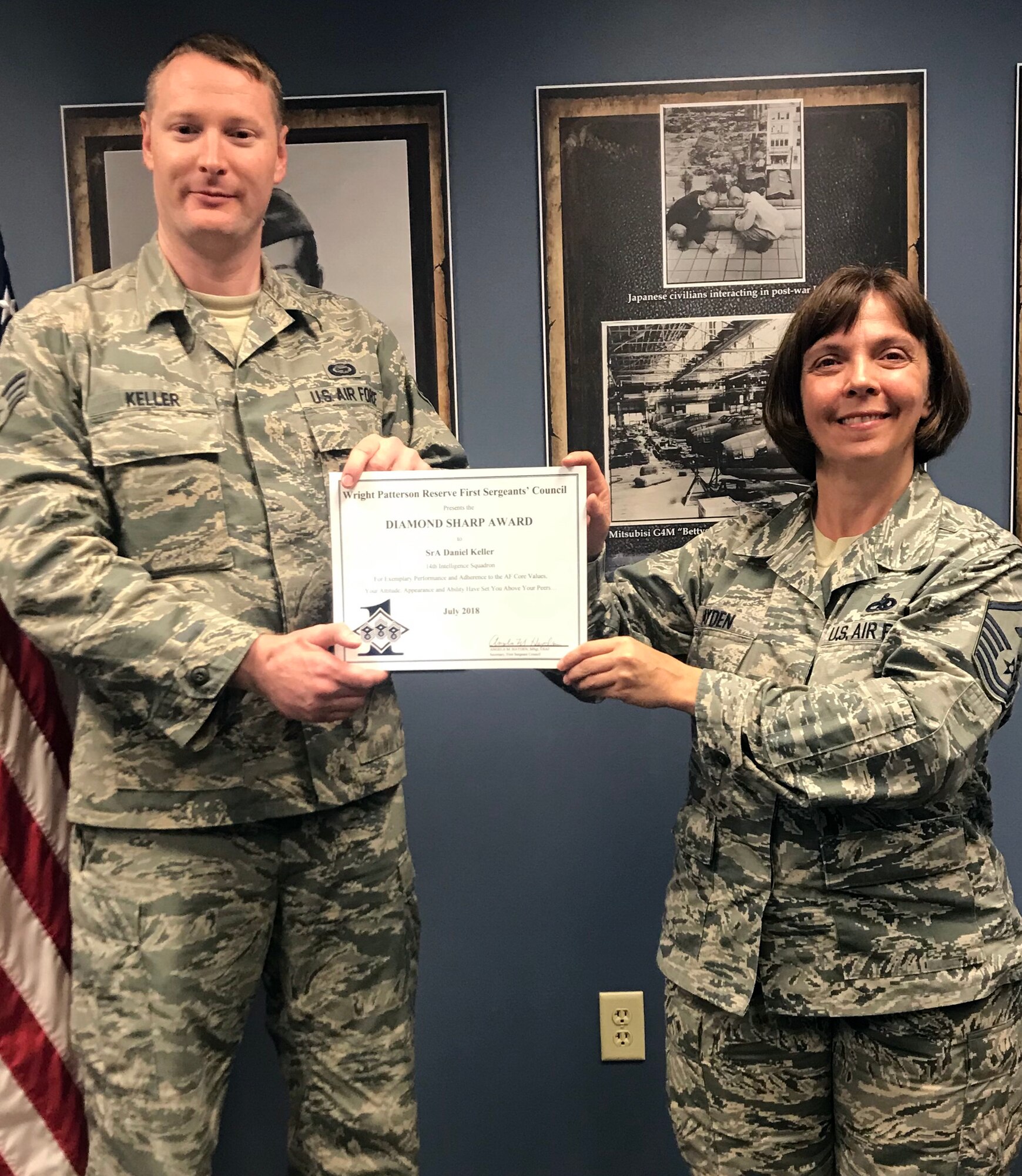 Master Sgt. Angela Hayden, 14th Intelligence Squadron first sergeant, presents the July 2018 Diamond Sharp Award to Senior Airman Daniel Keller, 14th IS intelligence analyst, during the September 23, 2018 unit training assembly. The award is for exemplary performance, adherence to the Air Force Core Values, attitude, appearance and ability.