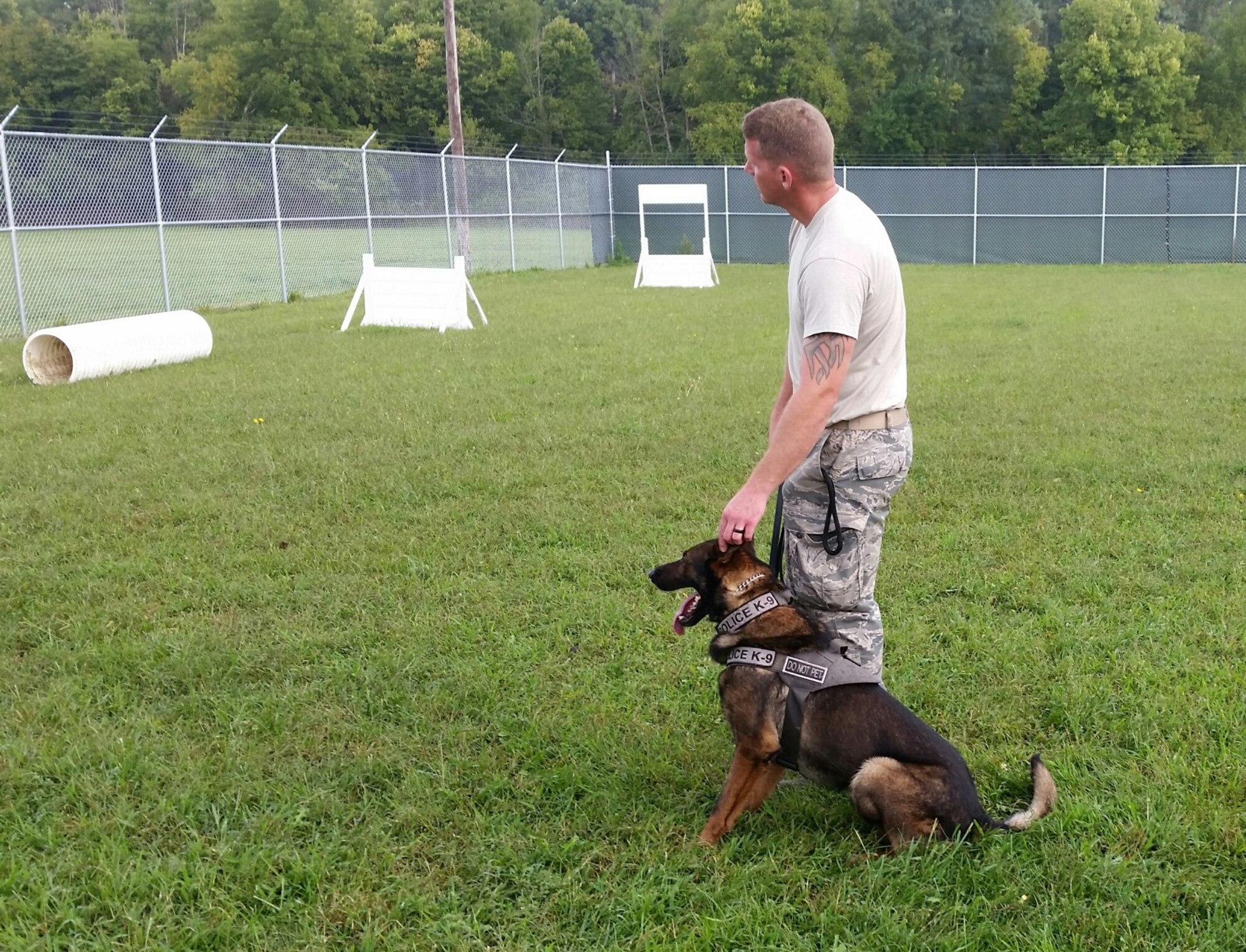 Staff Sgt. Phillip Mason, 88th Security Forces Squadron and kennel master, shows the Wright State University Raiders Hockey Team how his military working dog responds to commands on the obstacle course. (U.S. Air Force photo/W. Eugene Barnett Jr.)