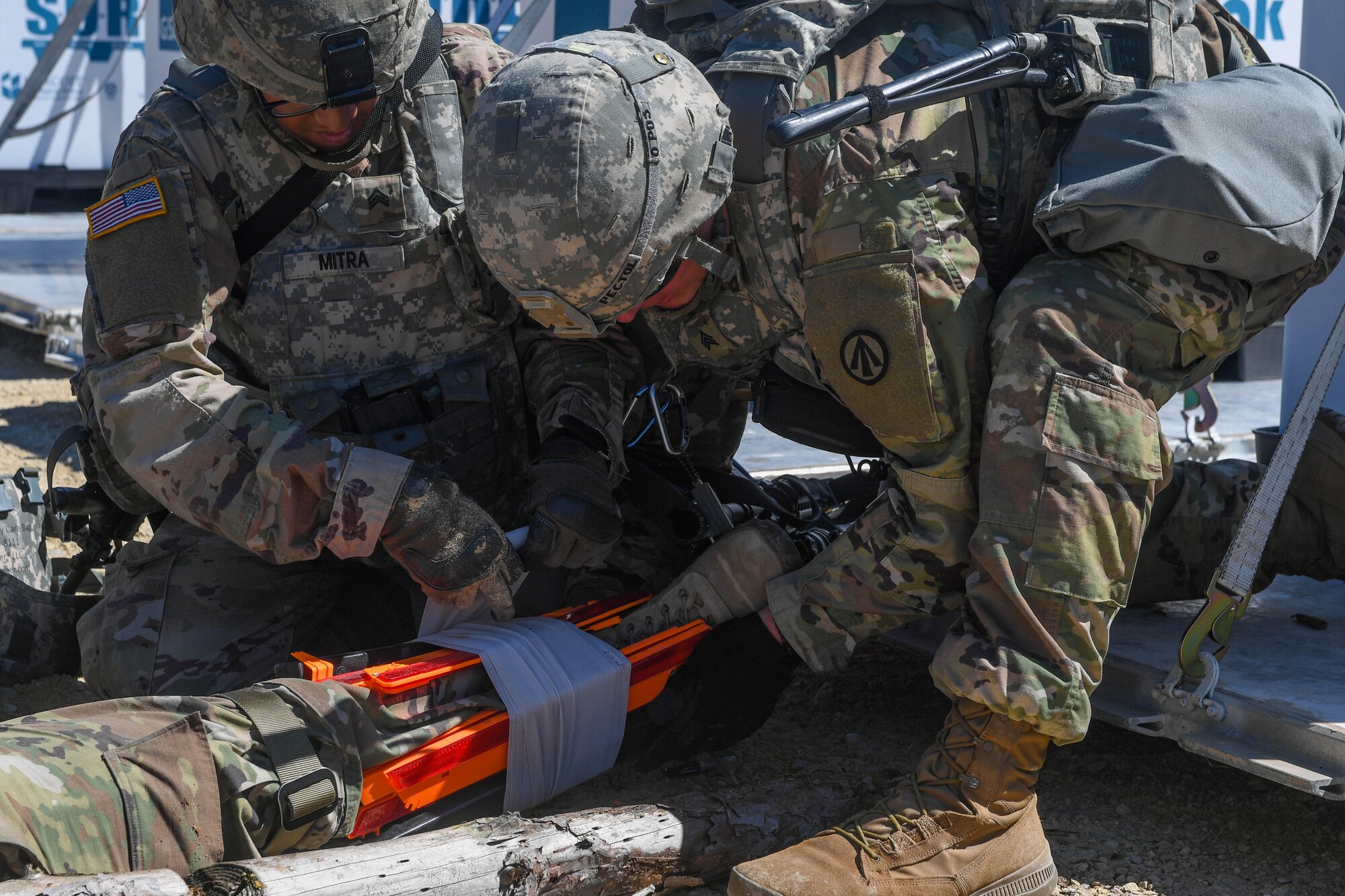 U.S Army Soldiers assigned to the 689th Rapid Port Opening Element, 832nd Transportation Battalion, 597th Transportation Brigade, use traffic triangles and ace bandage wrap to apply a splint to a simulated injury during Exercise Turbo Distribution 18-02 at Fort McCoy, Wisconsin, Sept. 9, 2018. The simulated injury forced the Soldiers to work together to stop bleeding and immobilize the injured Soldiers leg to reduce the risk of further injury. (U.S. Air Force photo by Senior Airman Derek Seifert)