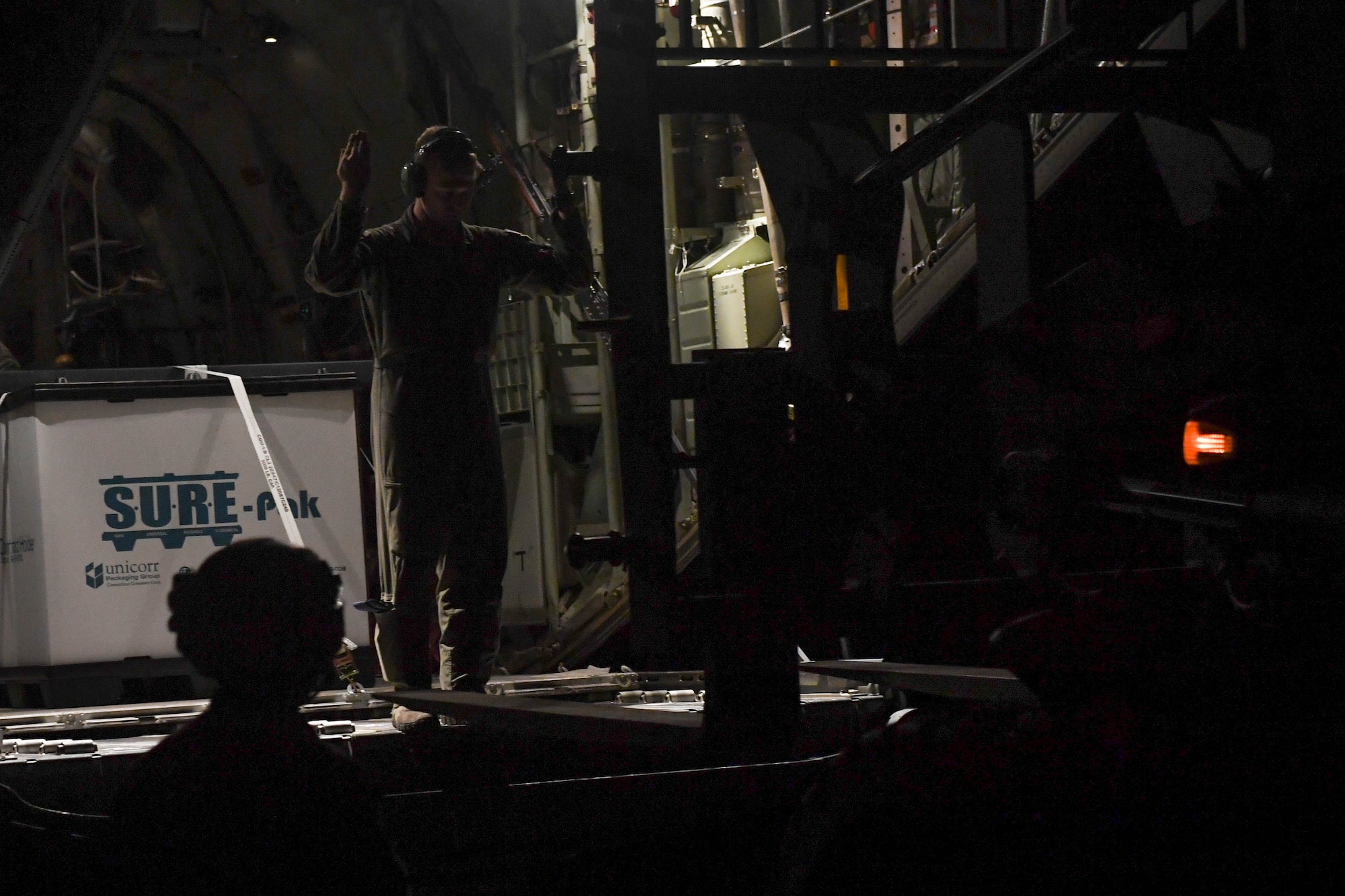 A U.S. Air Force Airman guides a forklift driver into position to unload cargo from a C-130J Super Hercules during Exercise Turbo Distribution 18-02 at Fort McCoy, Wisconsin, Sept. 9, 2018. The aircrew performed night cargo drop operations to test the Airmen and U.S. Army Soldiers abilities and proficiency in night scenarios. (U.S. Air Force photo by Senior Airman Derek Seifert)