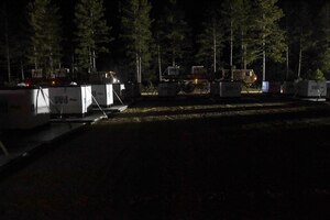 Trucks transport cargo boxes to the forward cargo yard at night during Exercise Turbo Distribution 18-02 at Fort McCoy, Wisconsin, Sept. 9, 2018. U.S. Army Soldiers and U.S. Air Force Airmen sustained 24-hour operations for a week-long exercise to test their capabilities in an environment similar to a real-world mission. (U.S. Air Force photo by Senior Airman Derek Seifert)