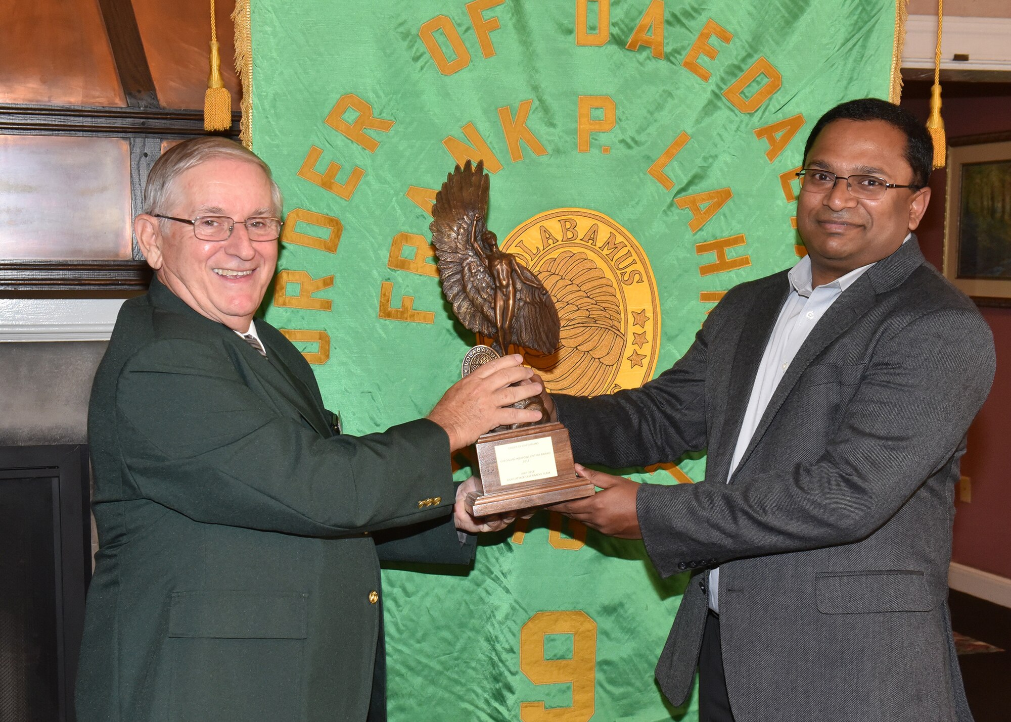 Jim DeStout, left, Adjutant, Flight 9 – Frank P. Lahm Order of Daedailians, presents the 2017 Daedalian Colonel Franklin C. Wolfe Weapon Systems Award trophy to Dr. Ravi Penmetsa, Light Attack Experiment Team Lead Sept. 20, 2018. The team’s combined efforts made the Phase I Experiment effort a huge success, which, in turn, paved the way for the Phase II Experiment in 2018 and the further development and maturation of the USAF Light Attack Aircraft acquisition strategy. (U.S. Air Force photo/Al Bright)