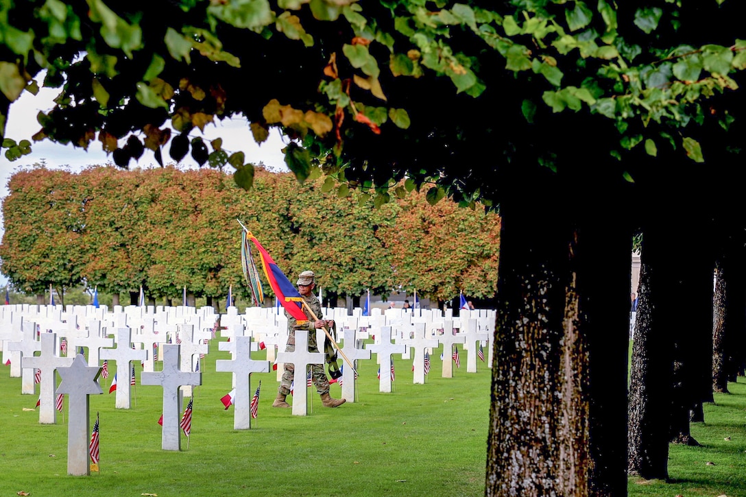 A service member walks between gravestones during a ceremony commemorating the St. Mihiel offensive of World War I.