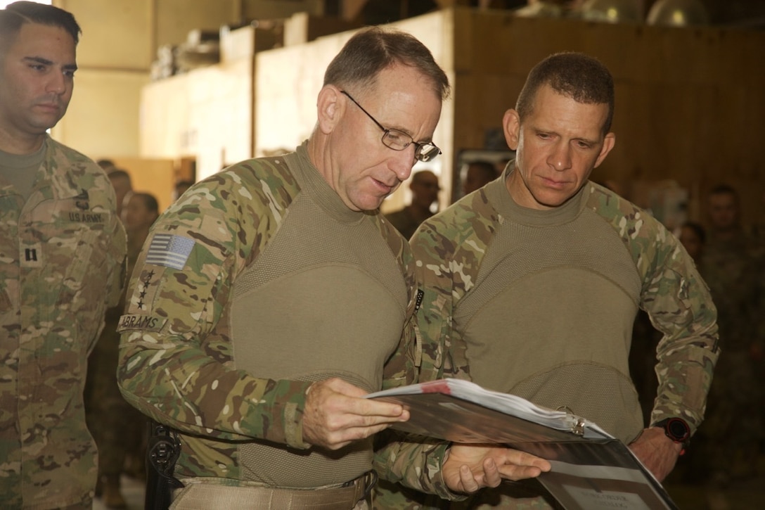 General and senior enlisted leader inspect soldiers' work.