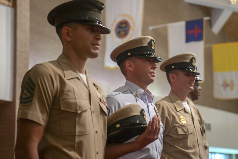 A Marine, Airman and Sailor stand at attention with their fellow graduates during a chief pinning ceremony Sept. 21, 2018, at the All Saints Chapel on Joint Base Charleston, S.C. The program is used to indoctrinate Sailors into the highest tier of its enlisted force. This class specifically offered the opportunity for Airmen and Marines to participate as well.