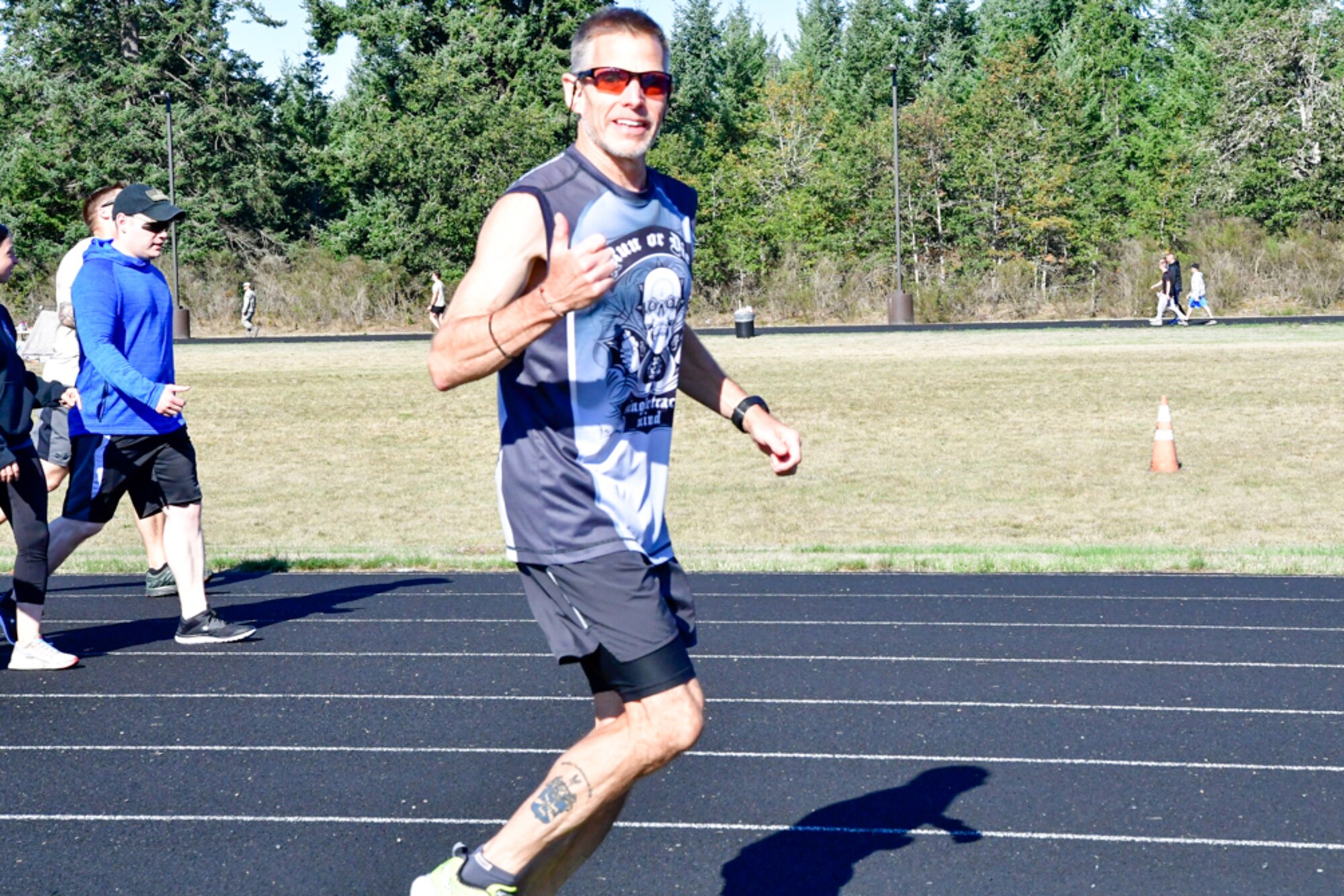 Bruce Robie, 225th Support Squadron National Airspace System Defense program manager, shows his enthusiasm for hitting mile 71 during the Joint Base Lewis-McChord 24-Hour POW/MIA Remembrance Run Sept. 19, 2018. Robie finished second in the individual standings with 74 miles. (U.S. Air National Guard photo by Maj. Kimberly Burke)