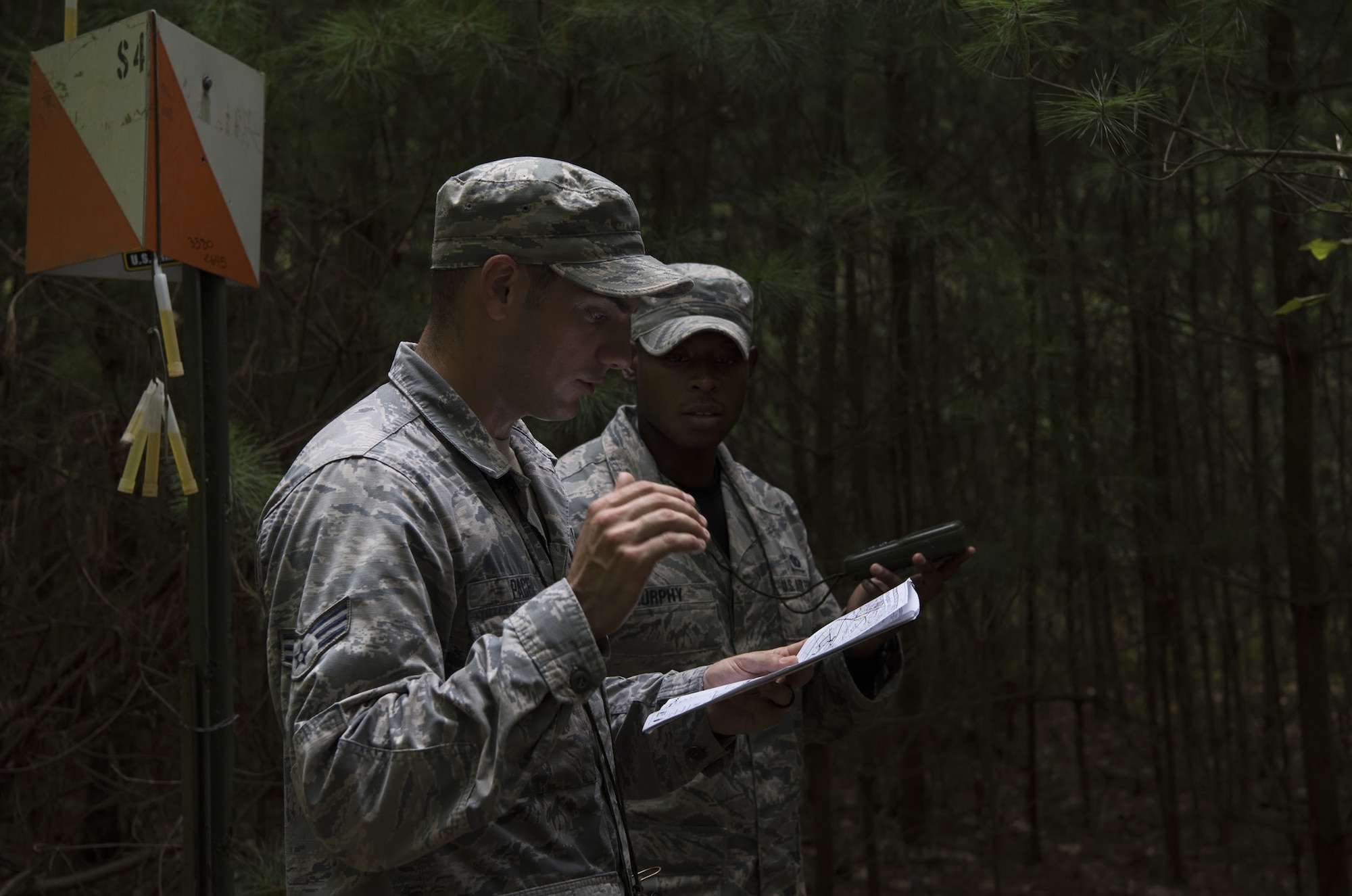 Senior Airman Joseph Pace, Fairchild Air Force Base, Washington, 92nd Security Forces Squadron installation patrolman, and U.S. Air Force Staff Sgt. Bryan Murphy, Joint Base McGuire-Dix-Lakehurst, New Jersey, 421st Combat Training Squadron Phoenix Raven instructor, navigate the woods using a map and GPS during land navigation training on Joint Base McGuire-Dix-Lakehurst, New Jersey, in preparation for representing Air Mobility Command in the 2018 Air Force Defender Challenge Sept. 7, 2018. Teams were instructed to find specific marked points using only a map and GPS to find their way.