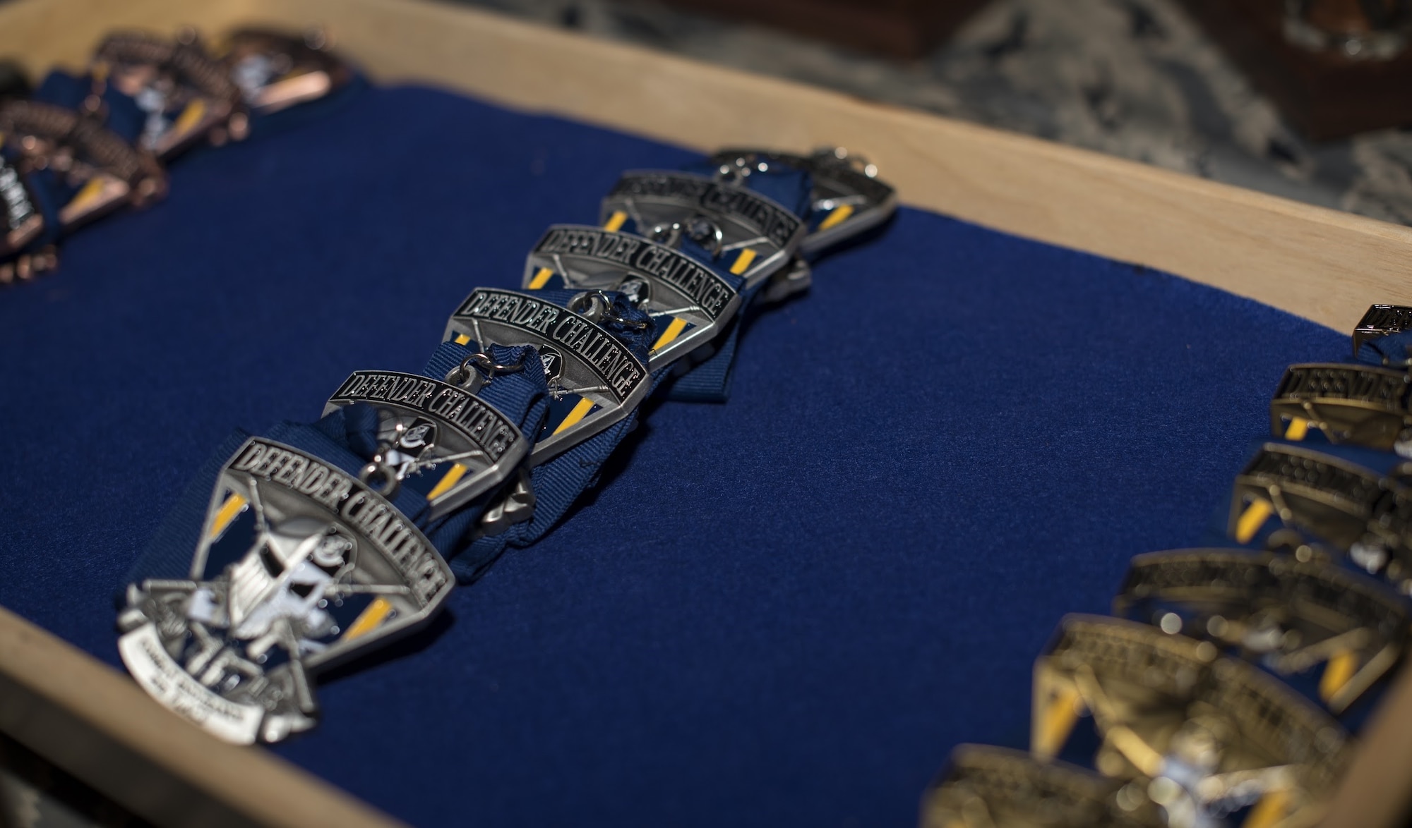 Medals sit in a tray during the 2018 Air Force Defender Challenge award ceremony on Joint Base San Antonio-Camp Bullis, Texas, Sept. 13, 2018. Gold, silver and bronze coins were awarded to place winners in the competition. The competition was comprised of weapons scenarios, dismounted operations and combat endurance. (U.S. Air Force photo by Airman Ariel Owings)