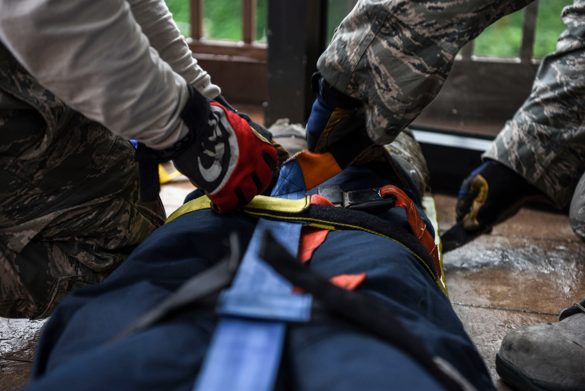 U.S. Air Force Staff Sgt. Jordan Salas, station captain at the 51st Civil Engineer Squadron fire and emergency services flight, and U.S. Air Force Senior Airman Jonathan Martinez crew chief at the 51st CES fire and emergency services flight, secure a simulated patient for evacuation during an exercise at Osan Air Base, Republic of Korea, Sept. 20, 2018. The joint mass causality exercise included members from the 51st Medical Group field response team and emergency services. (U.S. Air Force photo by Airman 1st Class Ilyana A. Escalona)
