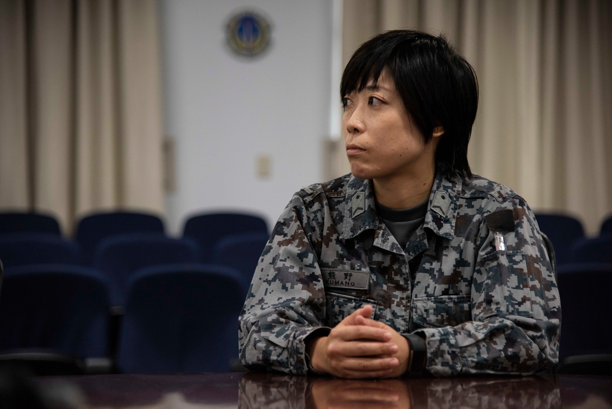 Japan Air Self-Defense Force Staff. Sgt. Kanazu Kumano, an Air Support Command Fuchu Sub Base dining facility menu creator, listens to introductions during a Bilateral Exchange Program visit at Misawa Air Base, Japan, Sept. 18, 2018. During the BEP, JASDF members from various bases partnered with Misawa AB Airmen to work together and further enhance each other’s mission tactics. (U.S. Air Force photo by Senior Airman Sadie Colbert)