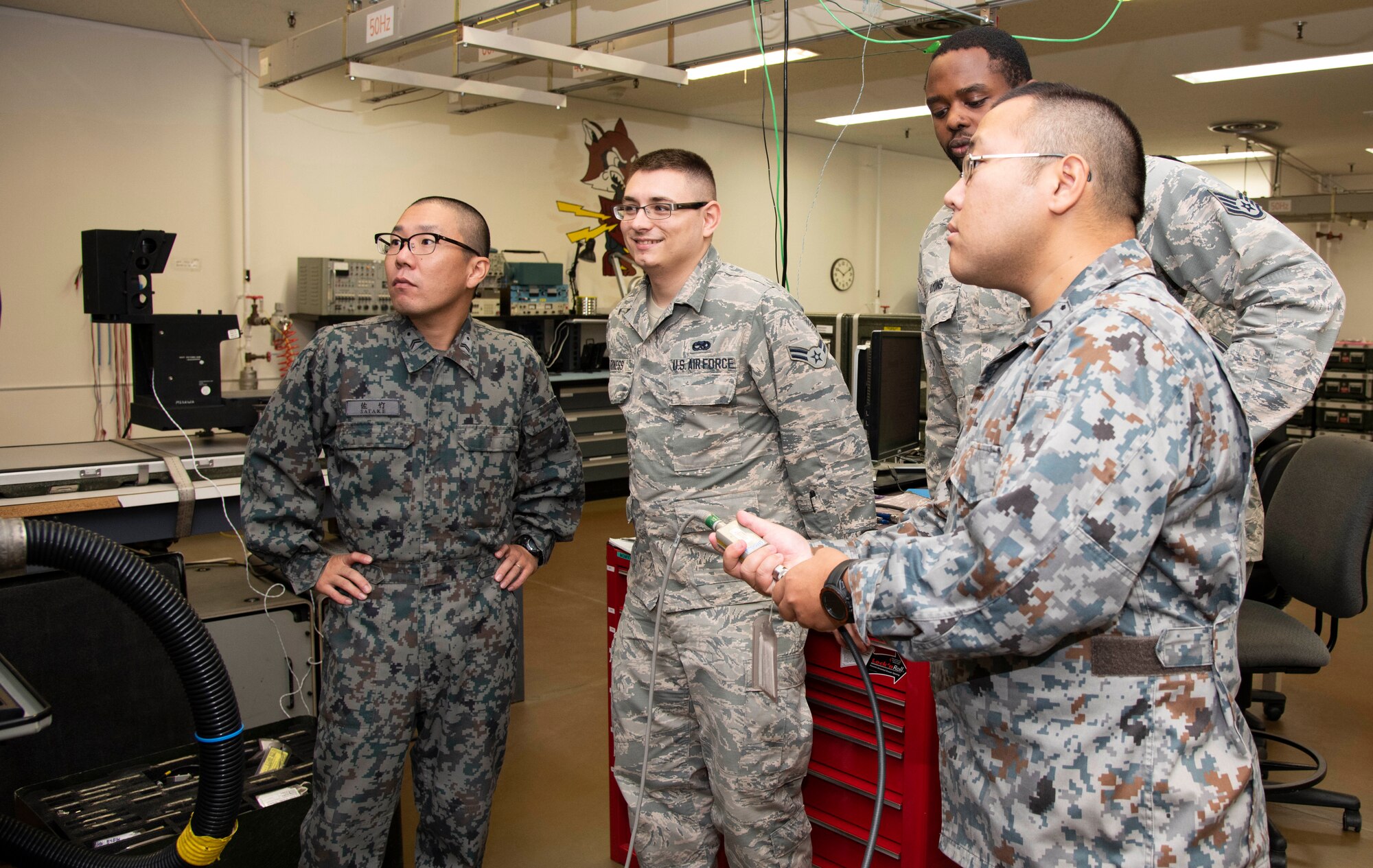 Japan Air Self-Defense Force and U.S. Air Force personnel follow a technical order for cable alignment during a Bilateral Exchange Program visit at Misawa Air Base, Japan, Sept. 20, 2018. The 35th Fighter Wing hosts these events in order to facilitate growth among the U.S. and its allies, while bonding together in a professional environment. (U.S. Air Force photo by Senior Airman Sadie Colbert)