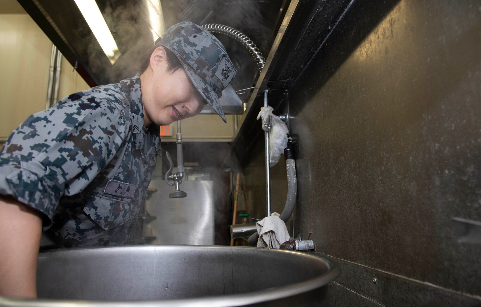 Japan Air Self-Defense Force Tech. Sgt. Tomoyo Kato, a 27th Aircraft Control and Warning Squadron nutritionist, stirs food in a large kettle during a Bilateral Exchange Program visit at Misawa Air Base, Japan, Sept. 21, 2018. The exchange group split into pairs to learn the similarities and differences between each other’s occupations. (U.S. Air Force photo by Senior Airman Sadie Colbert)