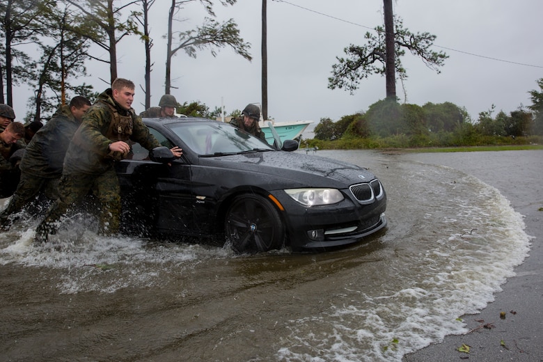 Marines with Marine Corps Base Camp Lejeune help push a car out of a flooded area during Hurricane Florence, on Marine Corps Base Camp Lejeune, Sept. 15, 2018. Hurricane Florence impacted MCB Camp Lejeune and Marine Corps Air Station New River with periods of strong winds, heavy rains, flooding of urban and low lying areas, flash floods and coastal storm surges. (U.S. Marine Corps photo by Lance Cpl. Isaiah Gomez)