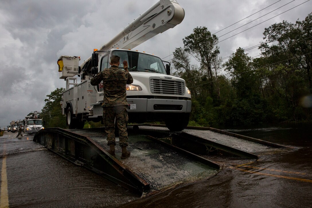 U.S. Marine Corps Cpl. Cameron D. Touchstone, left, combat engineer, Mobility Assault Company, 2nd Combat Engineer Battalion, 2nd Marine Division, directs traffic across an armored vehicle launch bridge after Hurricane Florence on Marine Corps Base Camp Lejeune, Sept. 16, 2018. Hurricane Florence impacted MCB Camp Lejeune and Marine Corps Air Station New River with periods of strong winds, heavy rains, flooding of urban and low lying areas, flash floods and coastal storm surges. (U.S. Marine Corps Photo by Lance Cpl. Isaiah Gomez)
