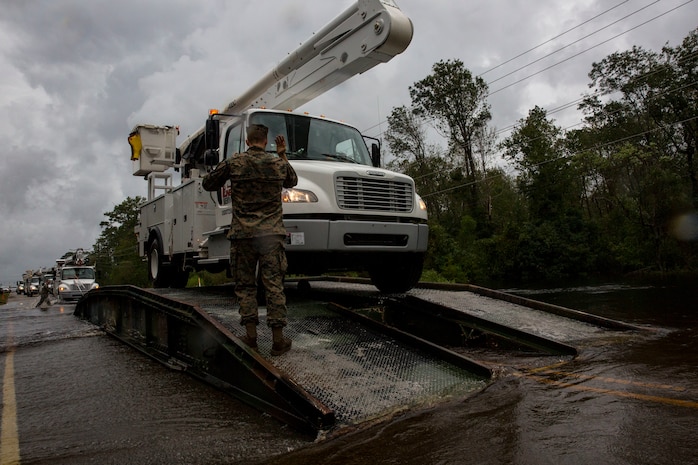 U.S. Marine Corps Cpl. Cameron D. Touchstone, left, combat engineer, Mobility Assault Company, 2nd Combat Engineer Battalion, 2nd Marine Division, directs traffic across an armored vehicle launch bridge after Hurricane Florence on Marine Corps Base Camp Lejeune, Sept. 16, 2018. Hurricane Florence impacted MCB Camp Lejeune and Marine Corps Air Station New River with periods of strong winds, heavy rains, flooding of urban and low lying areas, flash floods and coastal storm surges. (U.S. Marine Corps Photo by Lance Cpl. Isaiah Gomez)