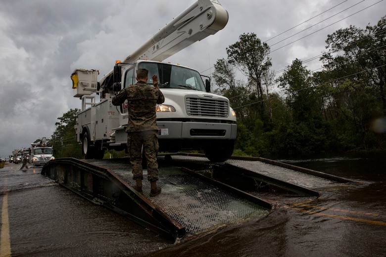 U.S. Marine Corps Cpl. Cameron D. Touchstone, left, combat engineer, Mobility Assault Company, 2nd Combat Engineer Battalion, 2nd Marine Division, directs traffic across an armored vehicle launch bridge after Hurricane Florence on Marine Corps Base Camp Lejeune, Sept. 16, 2018. Hurricane Florence impacted MCB Camp Lejeune and Marine Corps Air Station New River with periods of strong winds, heavy rains, flooding of urban and low lying areas, flash floods and coastal storm surges. (U.S. Marine Corps Photo by Lance Cpl. Isaiah Gomez)