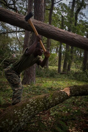 U.S. Marine Corps Lance Cpl. Jordan Thomas with Communications Company, Headquarters Regiment, 2nd Marine Logistics Group, chops a downed tree for removal at Camp Lejeune, N.C., Sept. 17, 2018. Recovery and repair efforts began on base Saturday, September 15, with the majority of efforts focused on clearing roadways and restoring power to critical areas at Camp Lejeune following Hurricane Florence. (U.S. Marine Corps photo by Sgt. Bethanie C. Sahms)