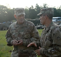 Maj. Gen. Flem B. “Donnie” Walker Jr., commanding general, 1st TSC, talks to First Sgt. Paul Gomez, first sergeant, Headquarters and Headquarters Company, 1st Special Troops Battalion, 1st TSC, Sept. 18 at Mount Eden. Walker visited the training site to speak with Soldiers and give command coins to selected individuals who showed outstanding hard work and dedication to their mission. (U.S. Army photo by Mr. Brent Thacker)