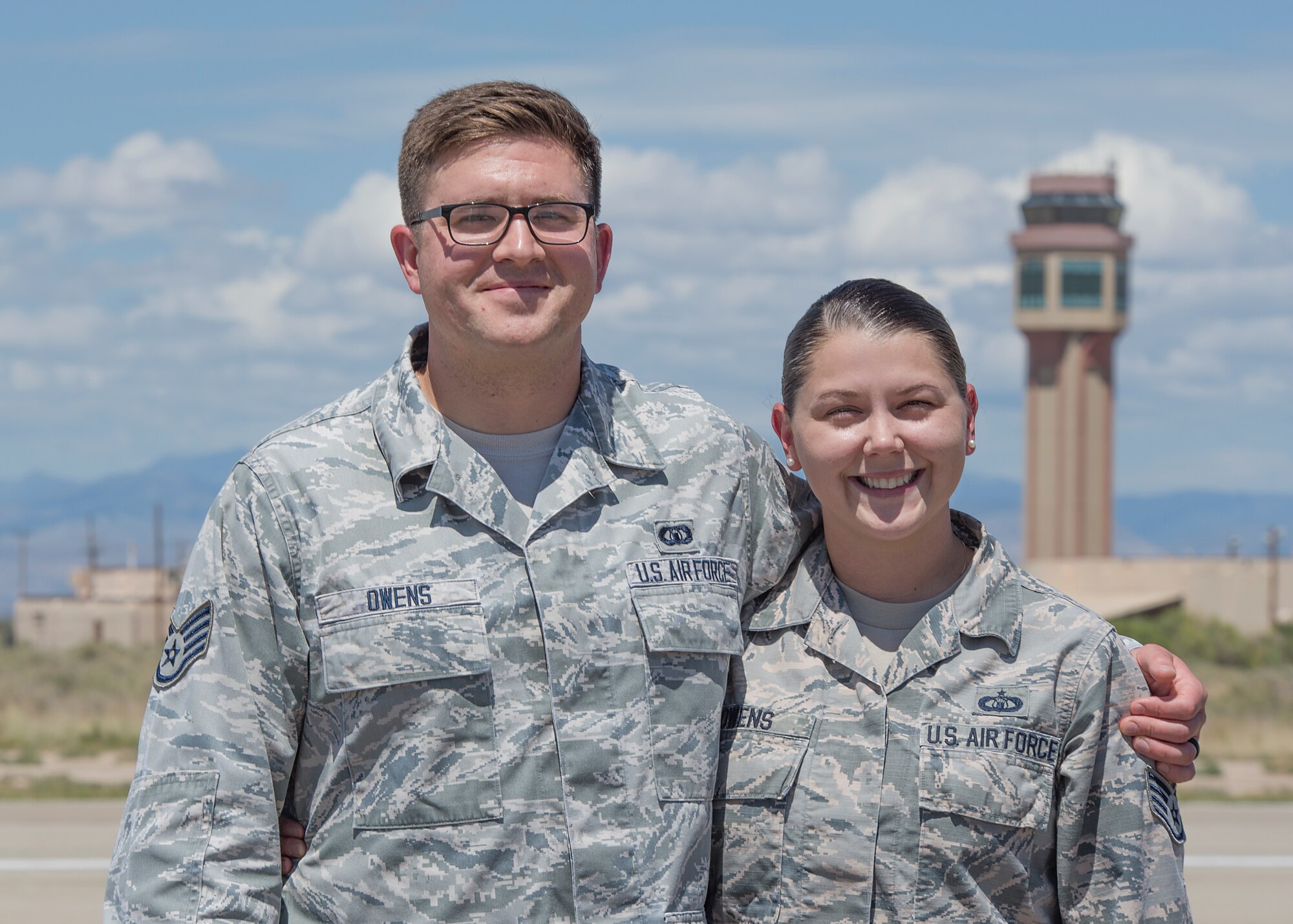 Staff Sgt. Colin Owens, 49th Wing Chapel religious affairs Airman, and Staff Sgt. Kristen Owens, 49th Operations Support Squadron air traffic controller, pose for a photo outside the air traffic control tower Aug. 23 on Holloman Air Force Base, N.M. While stationed at MacDill Air Force Base, Fla., Colin met and married his wife, Kristen, a fellow air traffic controller. (U.S. Air Force photo by Airman 1st Class Kindra Stewart)