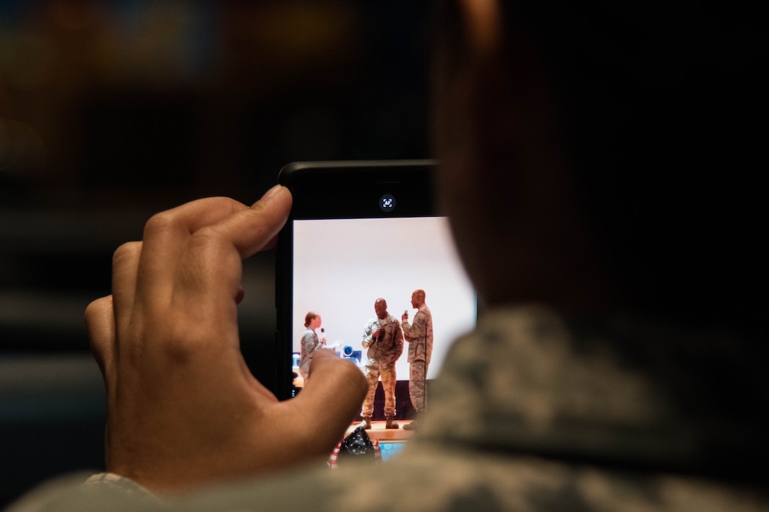 An audience member videos a skit performed at the “Creating Change Through Art” event held at the Langley Air Force Base Theater, Virginia, Sept. 25, 2018. The skit was meant to demonstrate potential Sexual Assault dangers in the workplace and allow for audience feedback on how to end negative behaviors. (U.S. Air Force Photo by Senior Airman Ericha Guyote/Released)