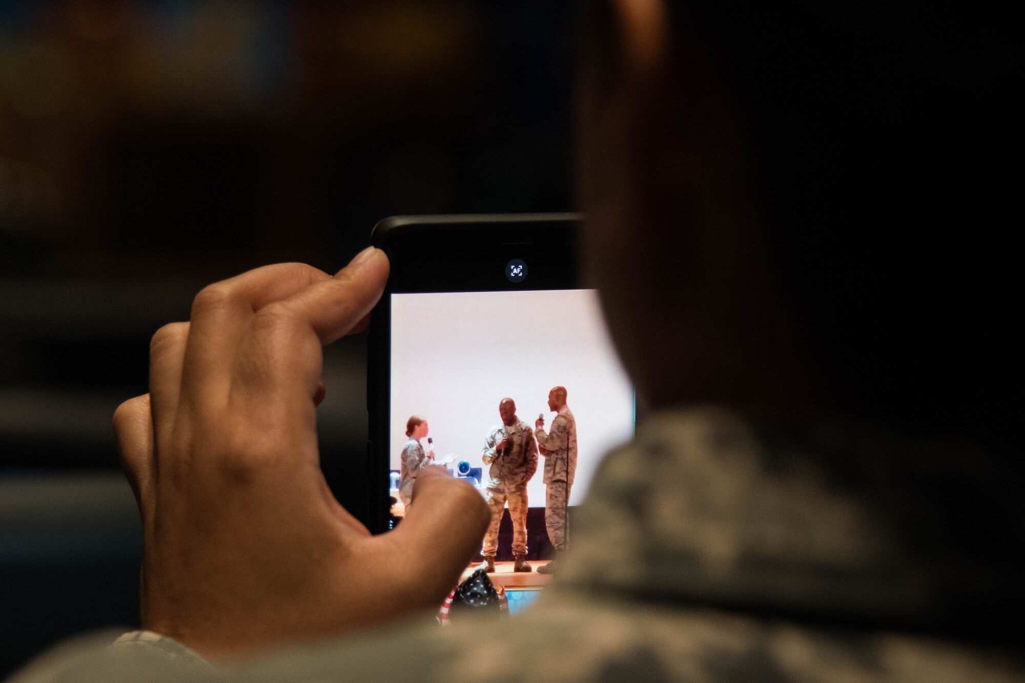 An audience member videos a skit performed at the “Creating Change Through Art” event held at the Langley Air Force Base Theater, Virginia, Sept. 25, 2018. The skit was meant to demonstrate potential Sexual Assault dangers in the workplace and allow for audience feedback on how to end negative behaviors. (U.S. Air Force Photo by Senior Airman Ericha Guyote/Released)