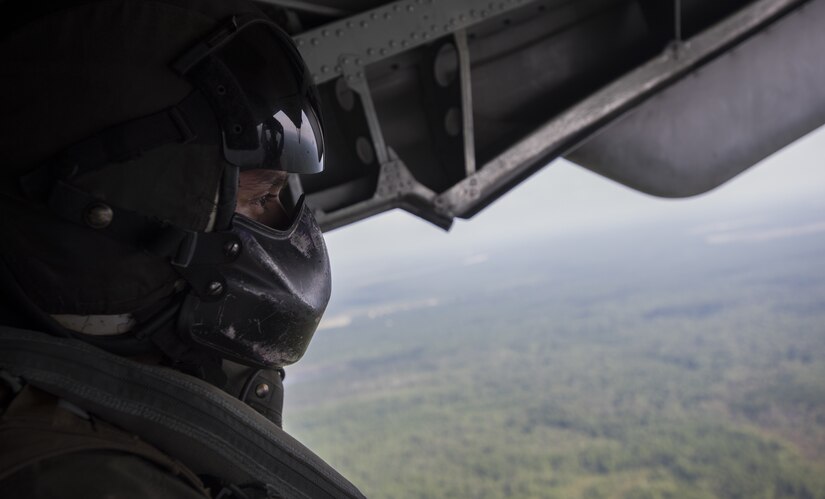 U.S. Marine Corps Sgt. Sebastian Chaverri, Marine Heavy Helicopter Squadron 772 (HMH-772) crew chief, looks out the back door of a Marine CH-53E Super Stallion flying over New Jersey Sept. 6, 2018. Chaverri said being a crew chief gives him the ability to fly every day and experience things he never would have if he wasn’t in the Marine Corps. (U.S. Air Force photo by Airman Ariel Owings)