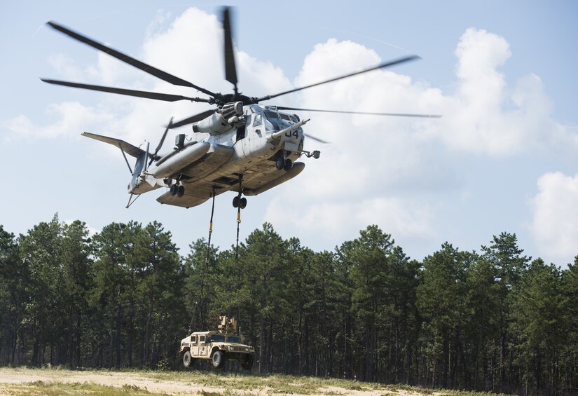 A U.S. Marine Corps CH-53E Super Stallion lifts a U.S. Army Humvee during a joint training exercise near Joint Base McGuire-Dix-Lakehurst, New Jersey, Sept. 6, 2018. The CH-53E lifted five different vehicles in place for 101st Airborne Division Soldiers and Marine Heavy Helicopter 772 Marines to practice how to safely and properly attach a vehicle and lift it off the ground. (U.S. Air Force photo by Airman Ariel Owings)