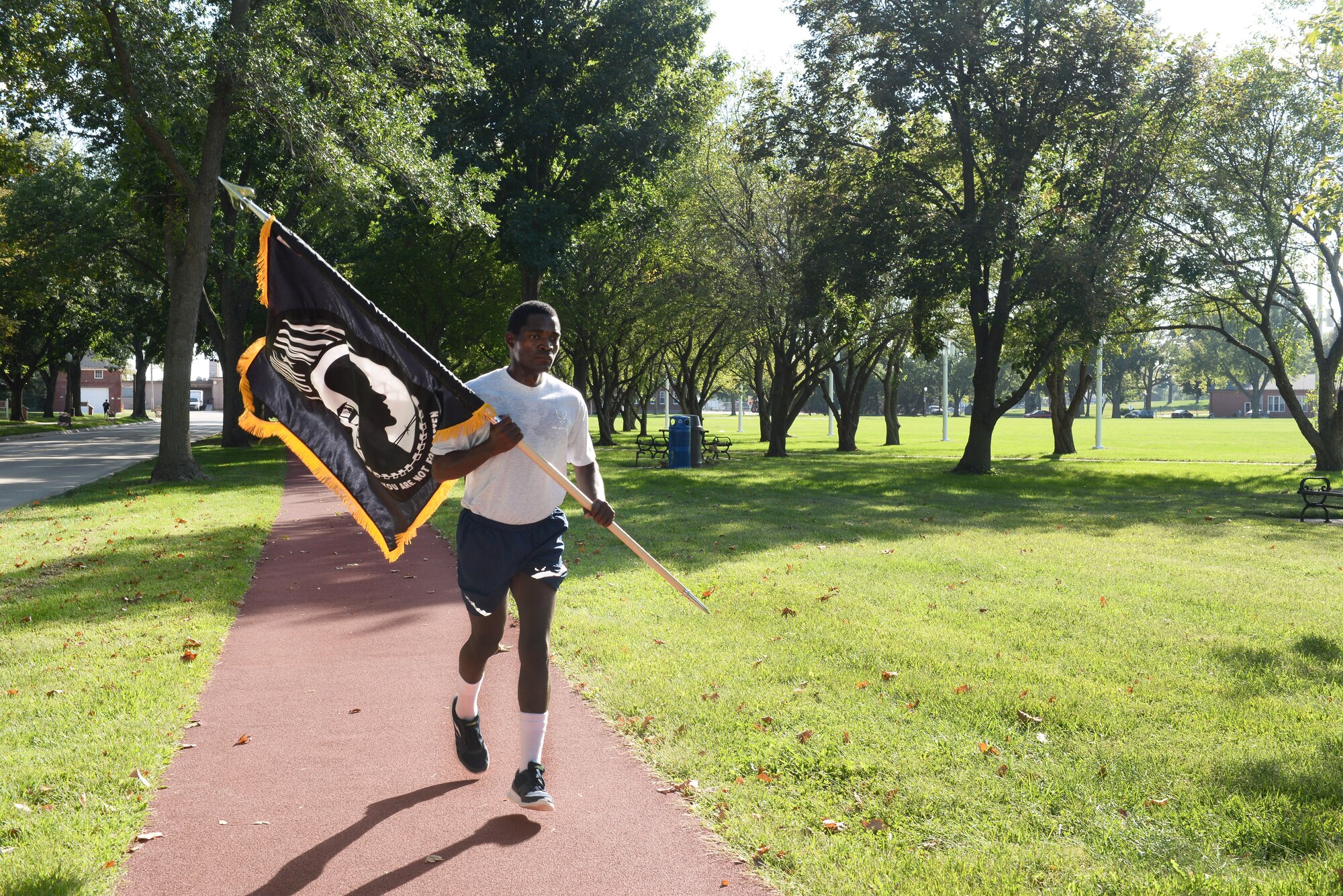 Airman 1st Class Abdulmajid Oamen, 55th Force Support Squadron food service journeymen, runs with the POW/MIA flag during the POW/MIA 24-Hour Vigil Run Sept. 14, 2018, at Offutt Air Force Base, Nebraska. Many Americans across the United States pause on the third Friday of September each year to remember the sacrifices and service of those who were POWs as well as those who are MIA and their families. (U.S. Air Force Photo by Charles J. Haymond)