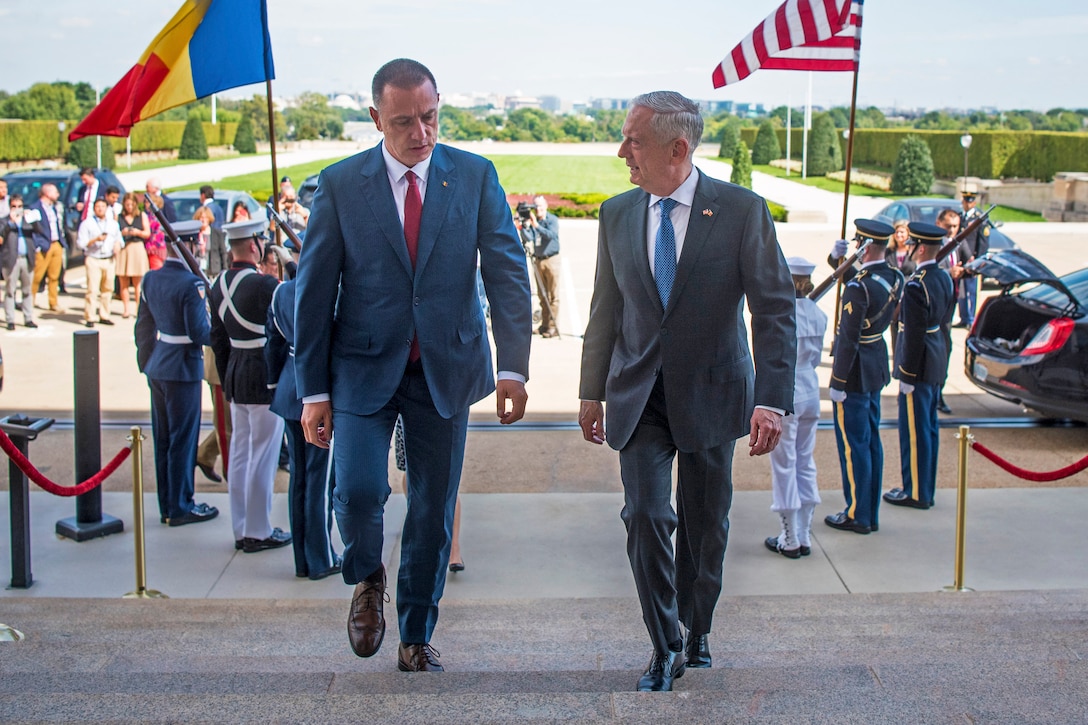 Defense Secretary James N. Mattis walks up the steps of the Pentagon with his Romanian counterpart.
