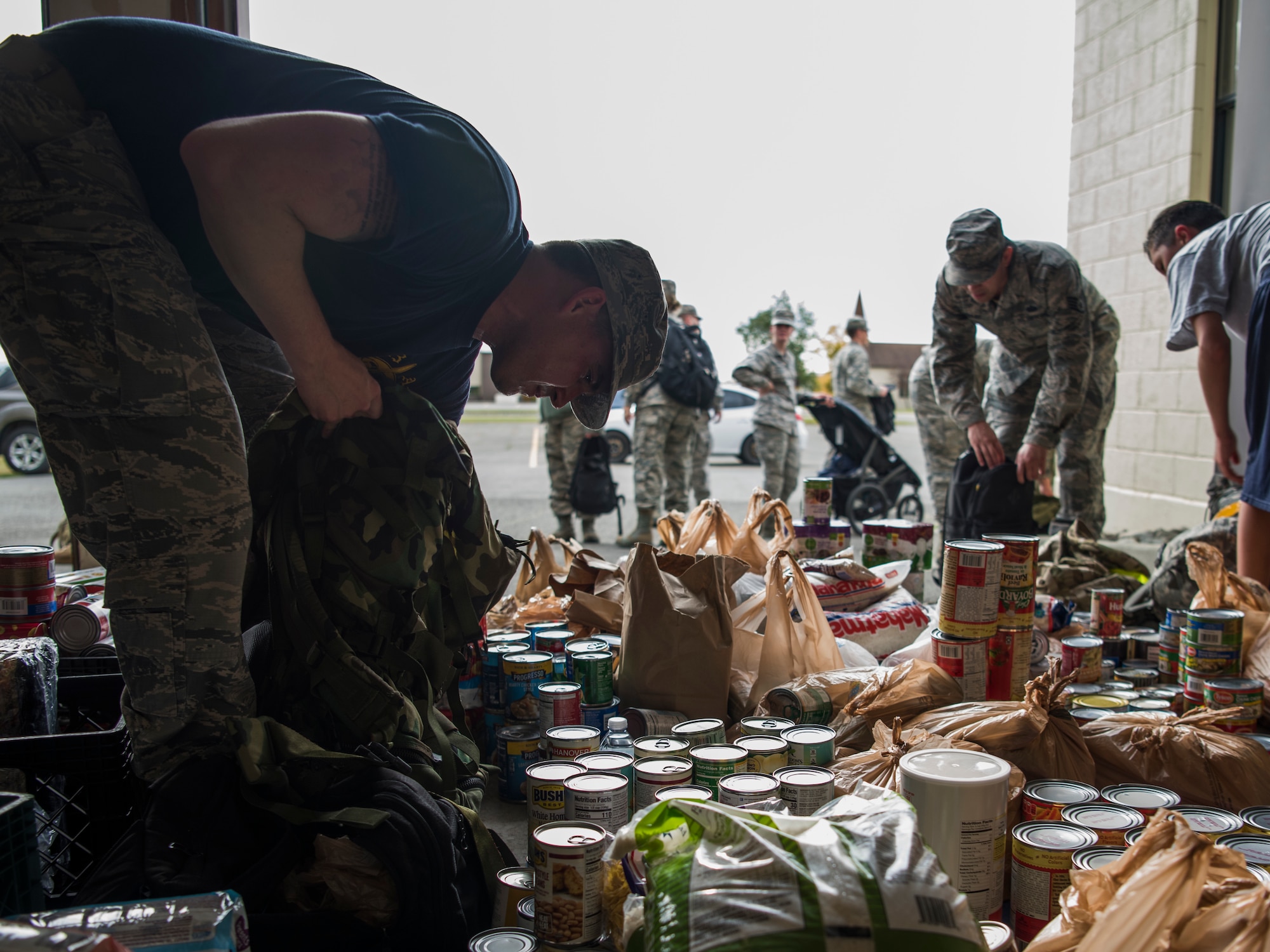 Joint Base Elmendorf-Richardson service members donate canned goods near the end of a POW/MIA ruck march through JBER, Alaska, Sept. 21, 2018. POW/MIA recognition day is observed every year on the third Friday in September and honors those who were prisoners of war and those who are still missing in action. Service members also attended a POW/MIA recognition ceremony.