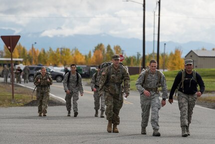 Joint Base Elmendorf-Richardson service members participate in a POW/MIA ruck march through JBER, Alaska, Sept. 21, 2018. Personnel carried canned food in their packs during the march and donated it to the Armed Services YMCA of Alaska. Service members also attended a POW/MIA recognition ceremony.