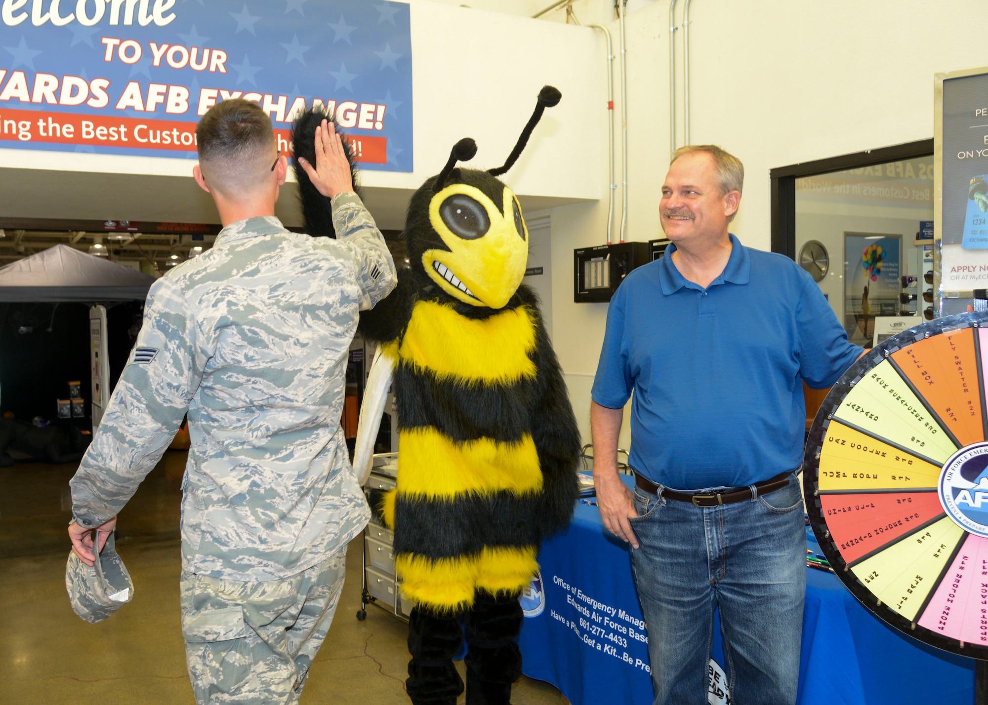 Eddie Bee Ready slaps fives with an Airmen at the Exchange along with Bill Hopper, 812th Civil Engineer Squadron Emergency Management Flight, Sept. 26, 2018. Members of Edwards Emergency Management have been at the Exchange throughout the month of September for National Preparedness Month. (U.S. Air Force photo by Giancarlo Casem)
