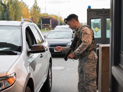 Airman 1st Class Brandon Calwile, a 673d Security Forces Squadron installation entry controller, checks identification at the Boniface Gate at Joint Base Elmendorf-Richardson, Alaska, Sept. 20, 2018. Installation entry controllers provide front-line installation security and must be thorough with every situation at the gates.