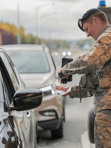 Airman 1st Class James Brown, a 673d Security Forces Squadron installation entry controller, checks identification at the Boniface Gate at Joint Base Elmendorf-Richardson, Alaska, Sept. 20, 2018. Installation entry controllers provide front-line installation security and must be thorough with every situation at the gates.