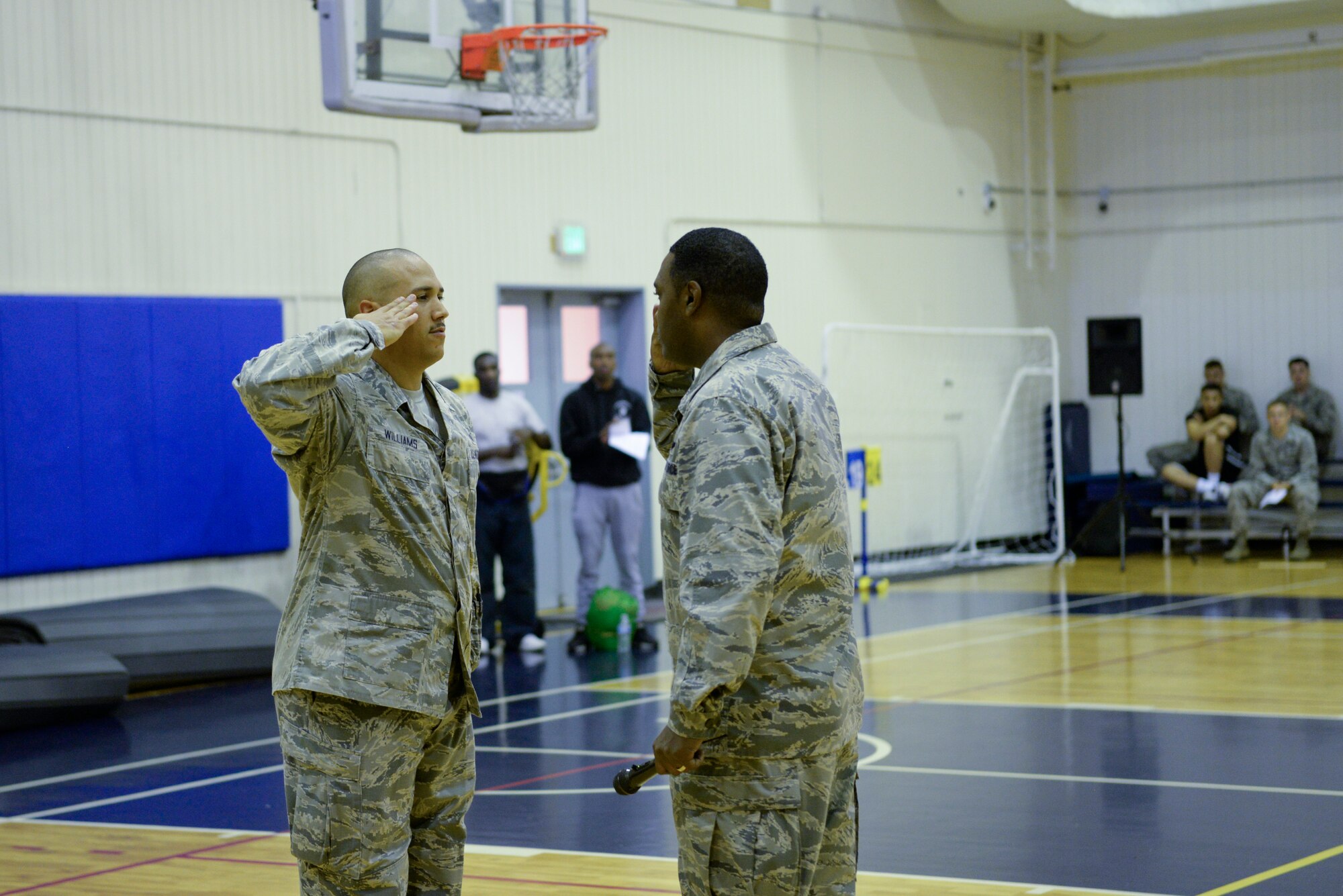 Col. Otis C. Jones, 374th Airlift Wing commander, right, and Master Sgt. Brian Williams, 341st Training Squadron operations superintendent, Lackland Air Force Base, TX, left, exchange salutes in the Samurai Fitness Center Sept. 26, 2018, at Yokota Air Base, Japan.