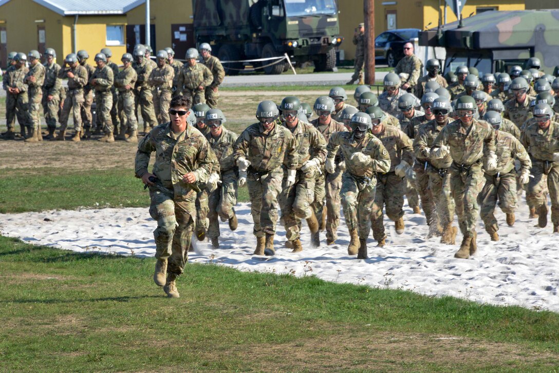 A soldier leads students to an assembly area before conducting rappelling training.