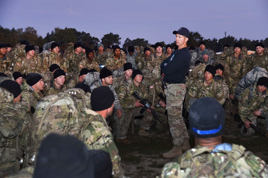 An Army air assault instructor gives an after action review to students after a ruck march during the final day of an air assault course.