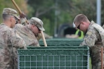 Sgt. Cody Puckett, 1226th Engineering Company training NCO and heavy equipment leader, fills a HESCO water barrier with dirt outside the Tidelands Health Georgetown Memorial Hospital in Georgetown, South Carolina, on Sept. 25, 2018. Approximately 2,000 South Carolina National Guard Soldiers and Airmen are on duty to support local authorities in response and recovery operations to the ongoing flooding that followed Hurricane Florence's landfall. National Guard Soldiers and Airmen from Alaska, Arkansas, Georgia, Maryland, New York, Tennessee, Virginia and Wisconsin are also supporting the South Carolina National Guard recovery efforts.