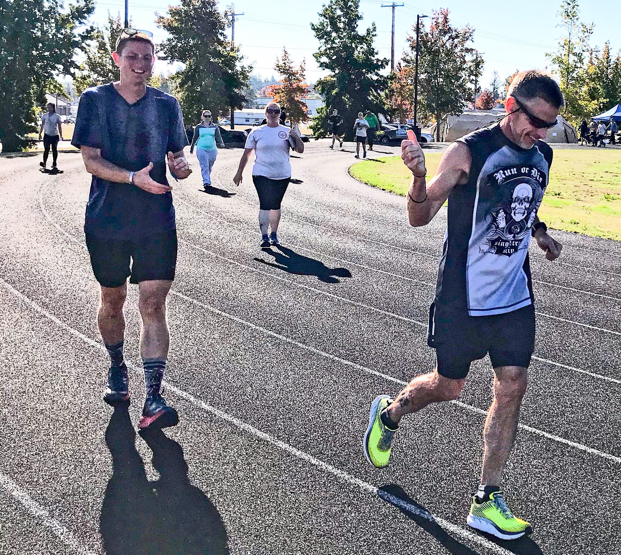 1st Lt. Krosby Keller, left, 225th Air Defense Squadron air battle manager, receives a thumbs up from running partner, Bruce Robie, right, when it was announced that Keller just completed running 100 miles during the 24-Hour POW/MIA Remembrance Run at Joint Base Lewis McChord, Washington, Sept. 19, 2018.  Keller placed first in individual standings with 100 miles and Robie finished second with 74 miles. (Courtesy photo)