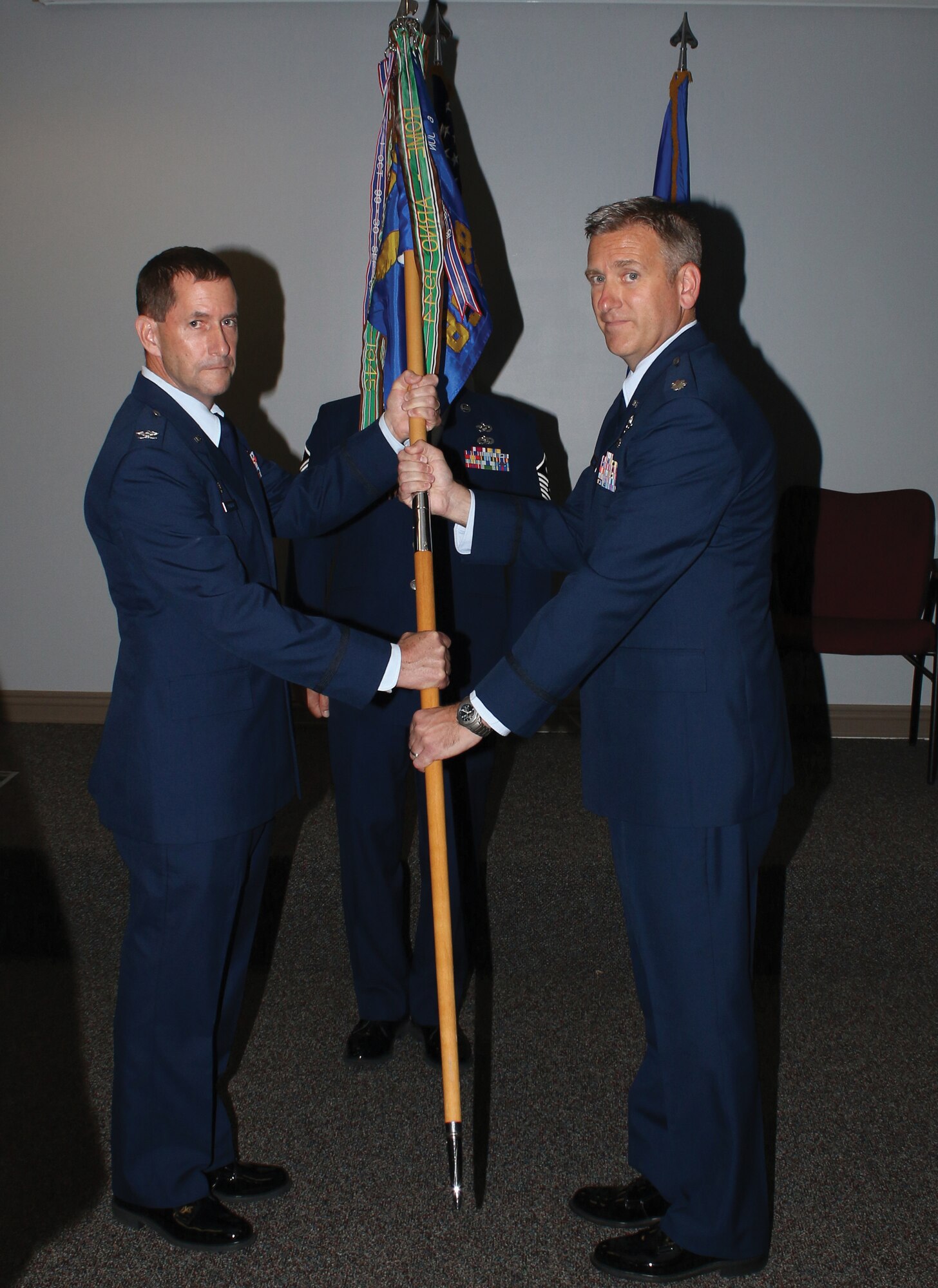 Col. John Robinson, 445th Operations Group commander, passes the guidon to Lt. Col. Brian Quinn, incoming 89th Airlift Squadron commander, during the 89th AS change of command ceremony Sept. 8, 2018